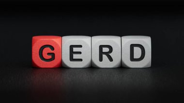GERD kelimesi tahta küplere yazılır. Tıbbi kavram. Ahşap elementlere yakın çekim, siyah arka planda 3D iş konsepti..