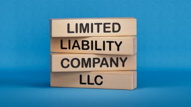 LLC-Sınırlı Sorumluluk Şirketi. LLC Business ve LLC konseptli tahta küpler. Boşluk 3D görüntülemesini mavi arkaplana kopyala.