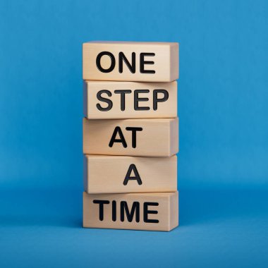 Zaman sembolünde bir adım. Kelimeleri kavramsallaştır. Ahşap bloklarda adım adım. İş ve konsept olarak adım adım. Boşluk 3D görüntülemesini mavi arkaplana kopyala.