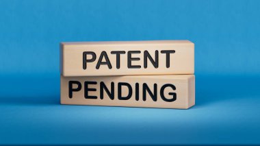 Patent bekleyen sembol. Tahta bloklarda bekleyen patent sözcüğü. İş ve Patent Bekleme konsepti. Boşluk 3D görüntülemesini mavi arkaplana kopyala.