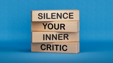 Silence your inner critic symbol. Wooden blocks with words Silence your inner critic.Business and Silence your inner critic concept.3D rendering on blue background. clipart