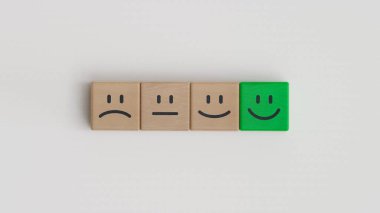 Müşteri hizmetleri değerlendirmesi ve memnuniyet anketi kavramları, değerlendirme, artış derecesi. Beyaz arka planda tahta küpte gülen surat simgesi