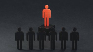 İnsanlar arasında ahşap insan modeli, Liderlik kavramı 3D siyah arka planda canlandırma.