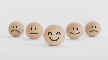 Müşteri hizmetleri değerlendirmesi, geri bildirim ve memnuniyet araştırması konsepti. Beyaz zemin üzerinde duygu yüzleri ve kopyalama alanı olan sevimli gülen yüz ifadeli tahta top blokları.