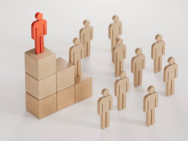 Tahta bir taş piramidin üzerinde duran tahta bebek. kariyer merdiveni kavramı, beyaz arkaplanda 3D kopyalama alanı ile iş hiyerarşisi.