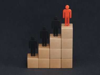 İş başarısı kavramına sahip liderlik. Büyüme grafiği üzerinde duran modern yükselen ok ve ahşap figürler, kopya alanı olan siyah arkaplanda izole edilmiş tahta küp bloklar tarafından düzenlenmiş basamaklar..