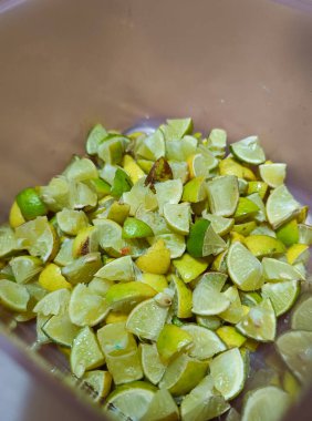 Bir kabın içinde birkaç dilim limon.