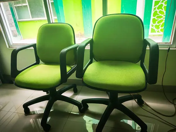 Pencerenin yanındaki yeşil sandalye.