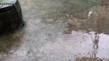 Asma kilitli bir kuyunun yanında sağanak yağmur