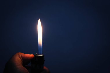 Benzin çakmağı karanlıkta yanıyor.