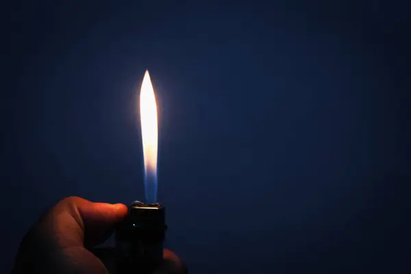stock image Gas lighter burns in the dark