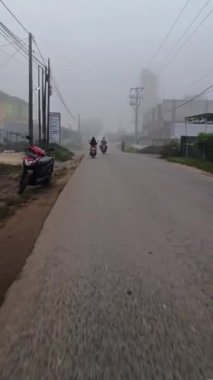 Güney Borneo-Endonezya, 7 Temmuz 2024: Sisli bir sabah, motosikletle seyahat