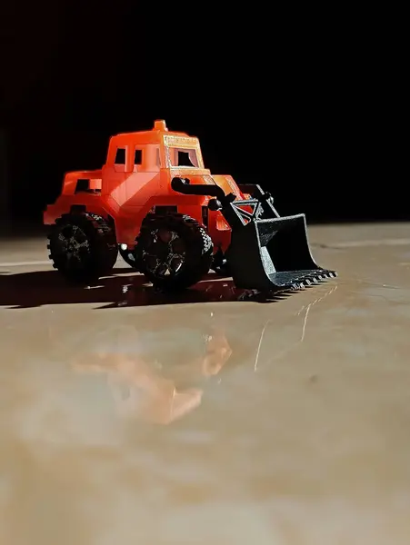Turuncu çocuk oyuncağı buldozer, güneş ışığı...