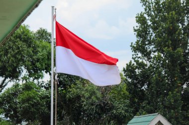 Indonesia's red and white flag that flutters on a sunny day, commonly called Sang Saka Merah Putih, Merah Putih, or somtimes called Sang Dwiwarna clipart