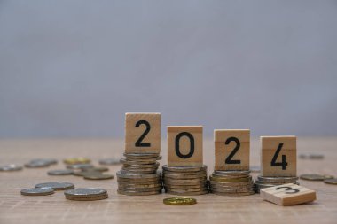 Tahta blok 2024 ve 2025 'e yerleştirilen bozuk paraların yakın plan çekimi, gevşek ve düşen para olasılığı ve istikrarsız gelecek, kazanılan veya harcanan para, ekonomik kriz riski ve iş sorunları kavramı