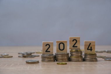 Tahta blok 2024 ve 2025 'e yerleştirilen bozuk paraların yakın plan çekimi, gevşek ve düşen para olasılığı ve istikrarsız gelecek, kazanılan veya harcanan para, ekonomik kriz riski ve iş sorunları kavramı