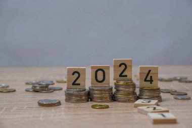 Tahta blok 2024 ve 2025 'e yerleştirilen bozuk paraların yakın plan çekimi, gevşek ve düşen para olasılığı ve istikrarsız gelecek, kazanılan veya harcanan para, ekonomik kriz riski ve iş sorunları kavramı