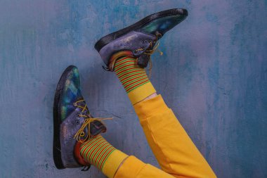 Erkek bacakları renkli çoraplar ve mavi duvarda ayakkabılar..