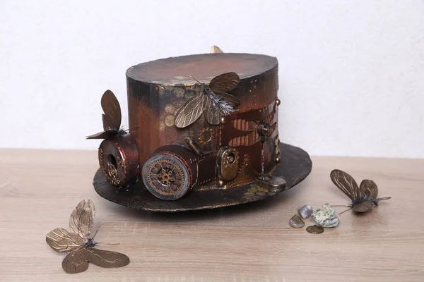 vintage steampunk hat on a wooden table with butterflies and leaves