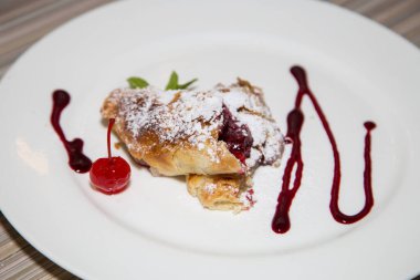 Lokantada beyaz bir tabakta tatlı meyveli turta