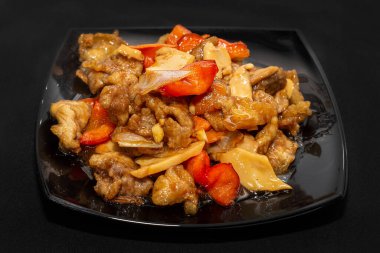 Çin yemeği, kızarmış domuz eti ve siyah tabakta dolmalık biber.