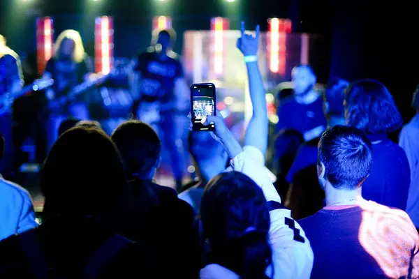 Crowd of people watching a live music concert on a mobile phone