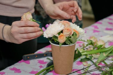 Çiçekçi çiçekçide gül buketi yapıyor..