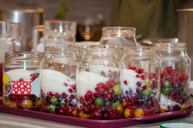 İçinde farklı meyve çeşitleri ve cam kavanozlarda böğürtlen olan çikolata.