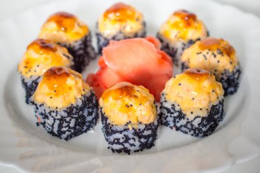 Sushi beyaz bir tabakta yuvarlanıyor, yakın plan, seçici odaklanma.