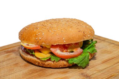Beyaz arka planda izole edilmiş kesme tahtasındaki büyük hamburger. Kapat..