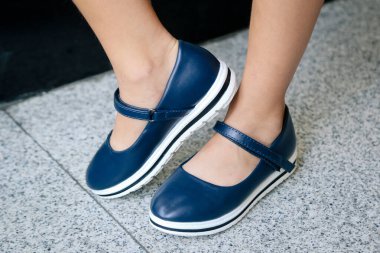 Merdivenlerde mavi ayakkabılı bir kadının bacaklarının yakın çekimi..