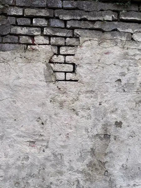 Ortasında delik olan eski tuğla bir duvar. Arkaplan ve doku.