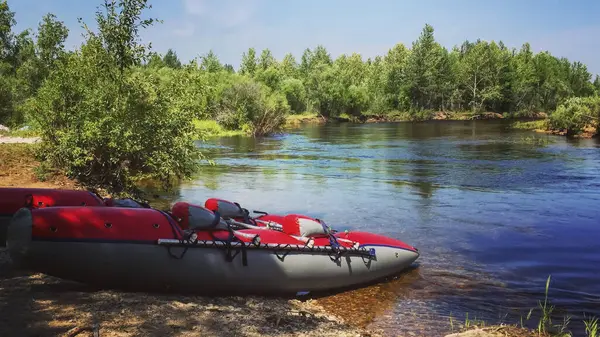 Inflatable kayak on the river bank on a sunny summer day