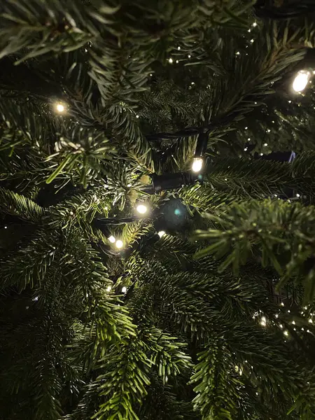 Christmas tree with light bulbs and garland. Selective focus.