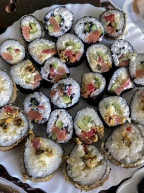 Somon, ton balığı, salatalık ve krem peynirli suşi..