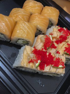 Japon restoranında suşi siyah tabakta yuvarlanır.