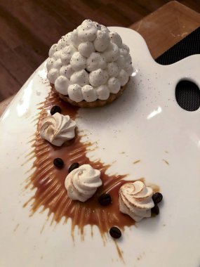 Kremalı pasta ve beyaz tabakta kahve çekirdeği.