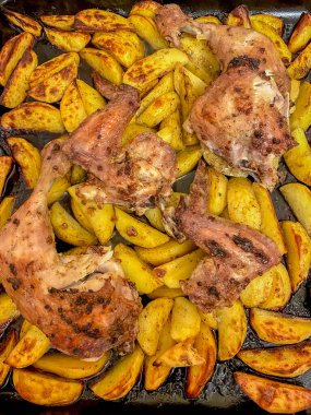 Kızarmış tavuk budu ve tavada patates. Üst görünüm.