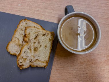 Tahta bir masada kahve ve ekmek. Üst görünüm.