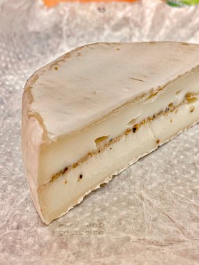 Beyaz küflü bir parça peynir ve kağıt kaplamalı mantar. Seçici odak.