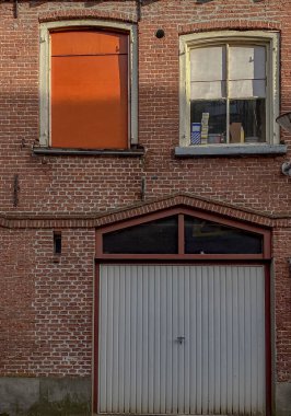 Kırmızı tuğladan bir duvarın yakın plan portakal renkli pencereleri var.
