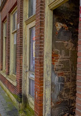 Hollanda 'da eski bir tuğla evin tuğla duvarı ve pencereleri.