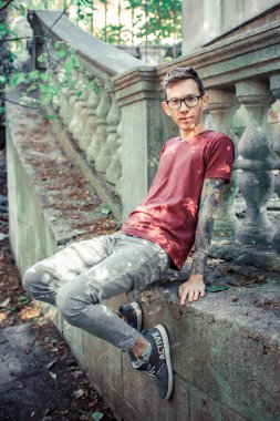 Oyma bir taş korkuluğun arkasında genç bir adam