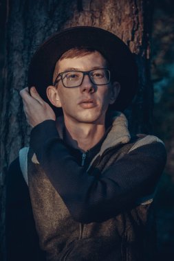 Gözlüklü ve şapkalı bir adam fotoğraf için poz veriyor..