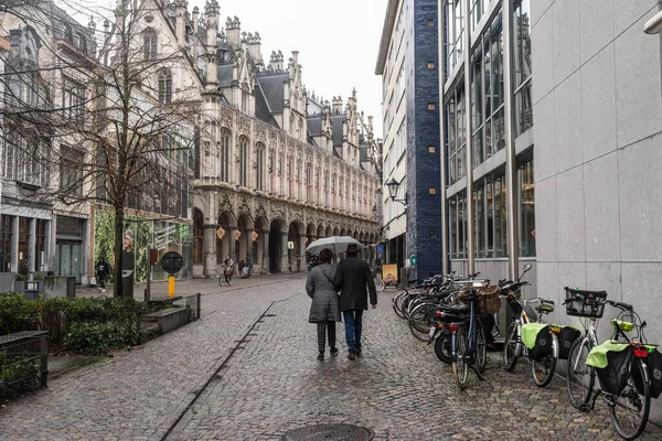 29 Aralık 2021: Mechelen, Belçika: Orta yaşlı bir çift şemsiye altında Grote Markt 'a doğru yürüyor.