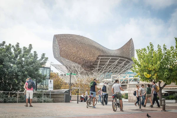 Barselona, İspanya - 10 Kasım 2015: İnsanlar Sanat Oteli Gehry Altın Balık Yapısı 'nın önünden geçiyorlar.