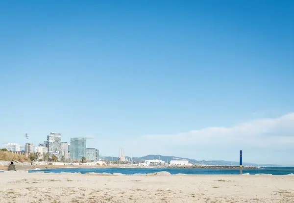 Barselona, İspanya - 23 Kasım 2019 - Playa Mar 'ın kenarında oturan kadın manzaranın tadını çıkarıyor.