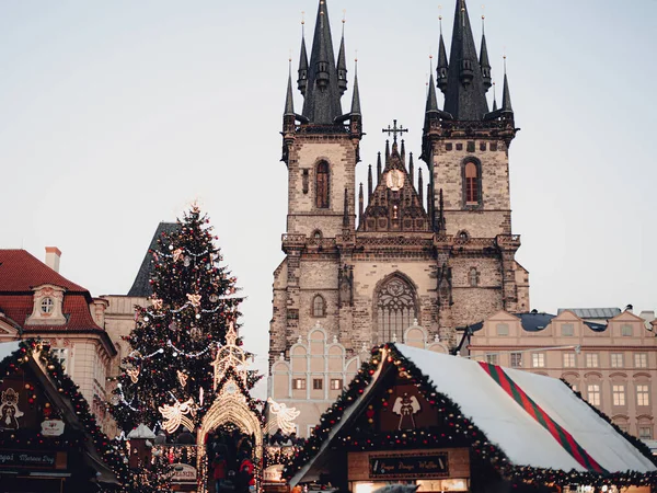 Prag 'da Noel pazarı, Çek Cumhuriyeti. Noel 'de Eski Şehir Meydanı, Yeni Yıl. Meryem Kilisesi' nden önce. Toplarla, oyuncaklarla, çelenklerle süslenmiş Noel ağacı. Çatısı karlı küçük evler. Avrupa 'da gotik mimari, Katolik kilisesi.
