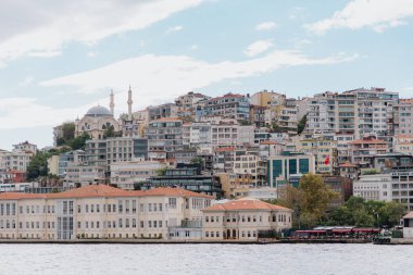 Boğazdan İstanbul 'un Findikli ilçesine, Türkiye' ye görüntü. Boğazın kıyısındaki Mimar Sinan Güzel Sanatlar Üniversitesi binası, öğle vakti, hafif ışık, geniş açı