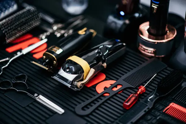 Tools for hairdressing salons, close-up. Scissors and clippers for hair and beard. Workplace, table of a barber, hair stylist, hairdresser. Hair comb. Black style.